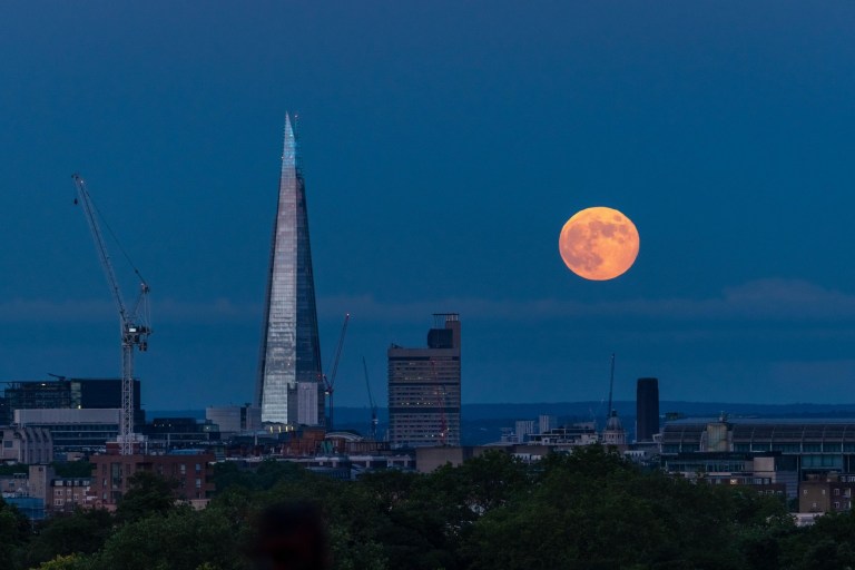 The moon rising behind the Shard in London