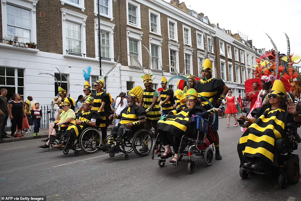 Notting Hill Carnival attendees dressed in yellow and black take part in Europes biggest street party this afternoon