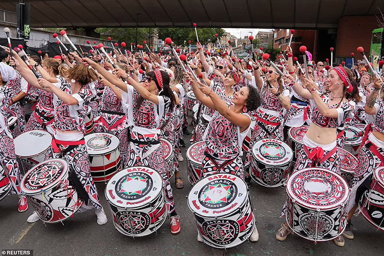 Performers take part in the Notting Hill Carnival in West London today as thousands of people descended to the area