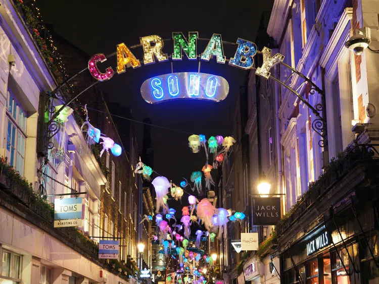 Carnaby Street in London at night time during christmas season.
