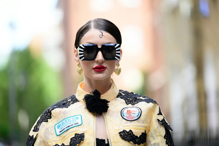 a woman wearing a yellow jacket and black sunglasses, London